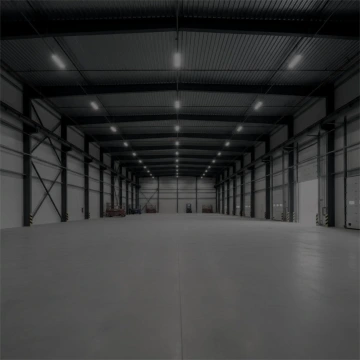 Prázdný moderní sklad s vysokým stropem a řadami stropních světel.