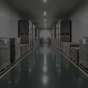 Skladová ulička s paletami zabalenými ve fólii, uspořádané podél stěn.